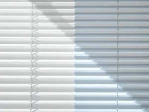 Witte lamellen jaloezie half schoongemaakt met microfiber doek, contrast tussen vuil en schoon gedeelte zichtbaar