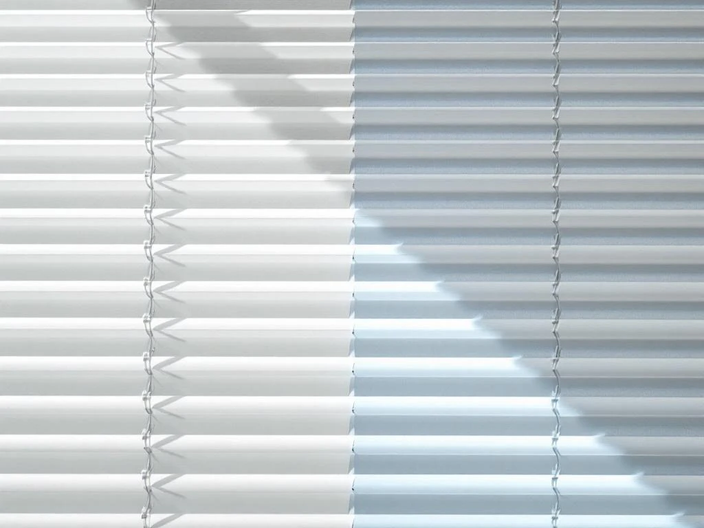 Witte lamellen jaloezie half schoongemaakt met microfiber doek, contrast tussen vuil en schoon gedeelte zichtbaar