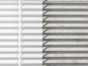 Schone witte venetiaanse jaloezie links contrasteert met stoffige, vuile lamellen rechts in natuurlijk licht